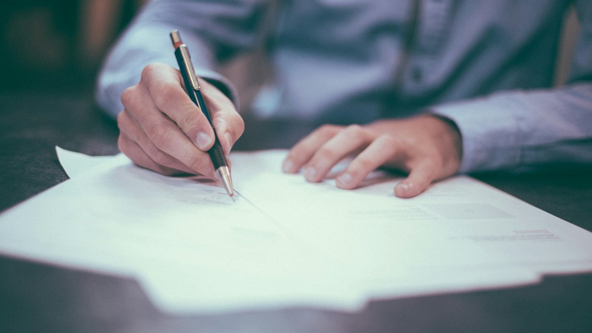 Contrat commercial annoté et stylo posés sur un bureau de dirigeant