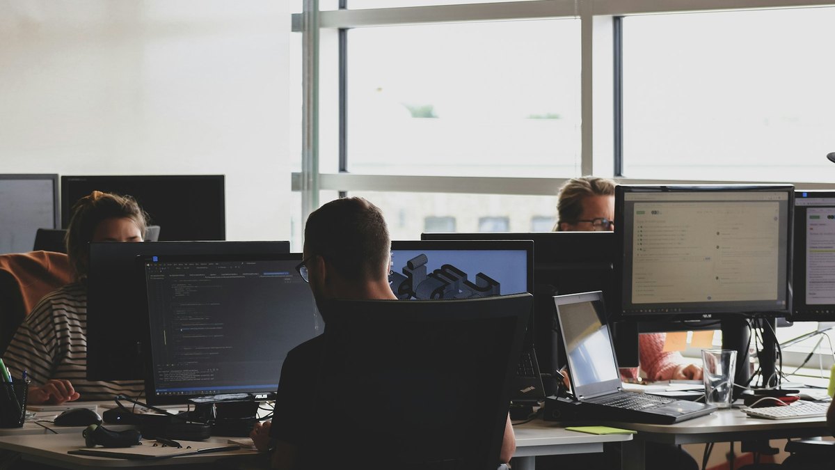 Écran de logiciel de gestion consulté par une équipe administrative de petite entreprise